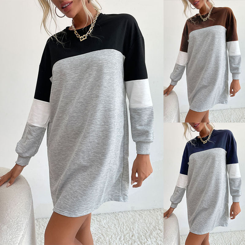 Color-block sweatshirt dress in gray, black, white. Gold chain necklace, curly hair