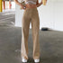 High-waisted beige straight-leg jeans with front pockets, shown on model wearing white crop top and sneakers in parking garage
