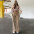 Full outfit view of beige straight-leg jeans styled with white sports bra, beige cap, and cream overshirt in parking structure