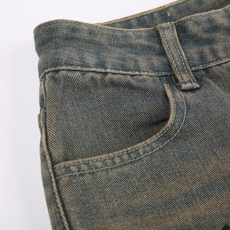 Detail shot of gray jeans waistband and pocket construction with worn-in wash effect