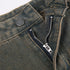 Close-up of gray jeans button closure and metal zipper detail on distressed denim