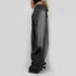 Side profile of gray oversized wide-leg jeans, showing relaxed fit silhouette and black and white chunky sneakers