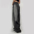 Detail shot of ultra-wide gray denim jeans showing relaxed silhouette and pocket detail, styled with black and white shoes
