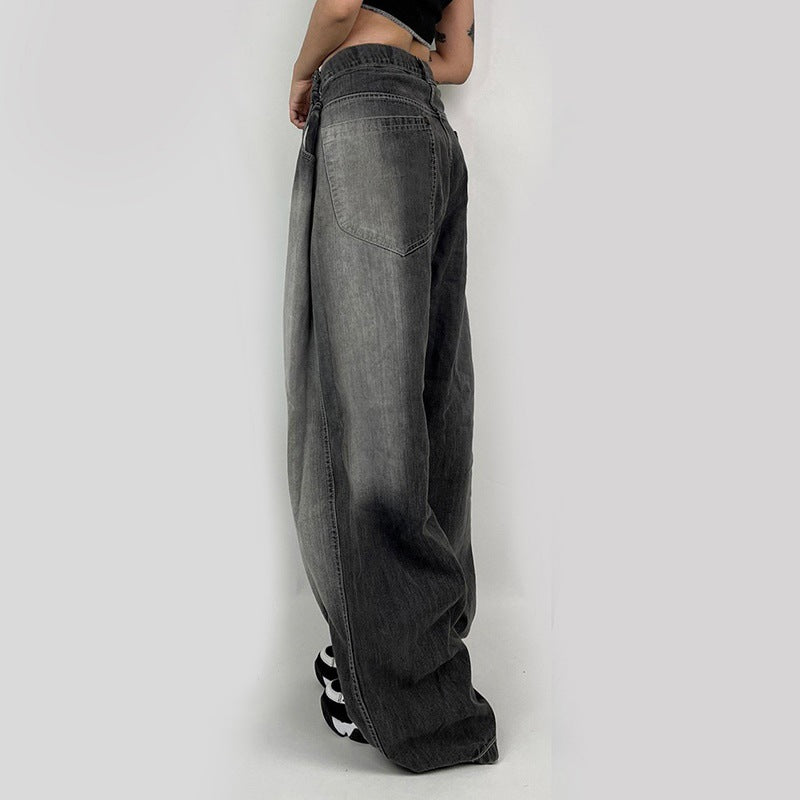 Detail shot of ultra-wide gray denim jeans showing relaxed silhouette and pocket detail, styled with black and white shoes