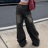 Backside of black washed wide-leg jeans showcasing embroidered pockets and a relaxed fit, styled with a white crop top and red shoulder bag