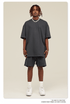 Man wearing charcoal gray oversized T-shirt and shorts set with white Air Force 1 sneakers