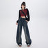 Model posing in oversized dark denim wide-leg jeans, burgundy crop top with black sleeves and platform sneakers on white background