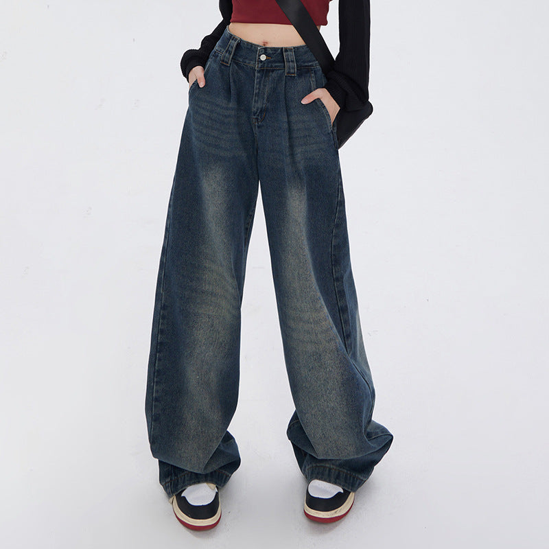 Model wearing ultra-wide leg medium-wash jeans with hands in pockets, burgundy crop top and platform shoes against white background