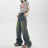 Woman wearing grey 'Bad Girls' crop top, wide-leg jeans with side stripe detail and platform sneakers, carrying chain strap bag against white background