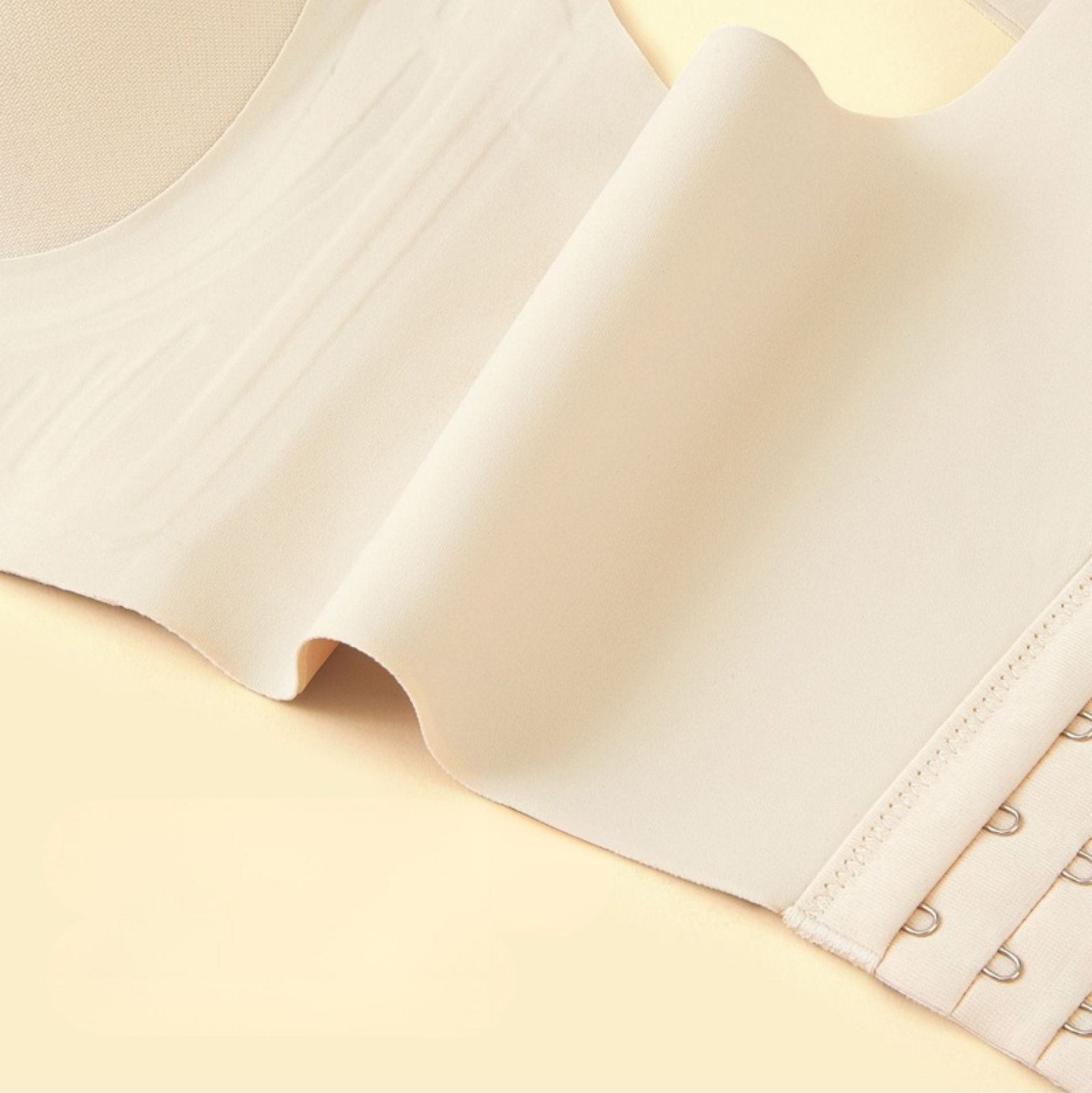 A smooth, stretchable beige bra side panel designed to flatten underarm fat and provide breathable comfort.