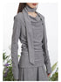 Detail view of gray top highlighting asymmetrical neckline and integrated scarf wrap