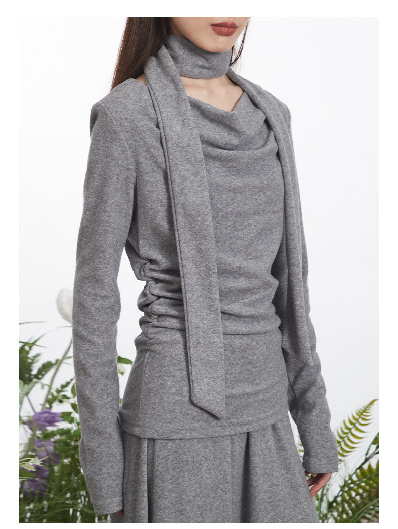 Detail view of gray top highlighting asymmetrical neckline and integrated scarf wrap