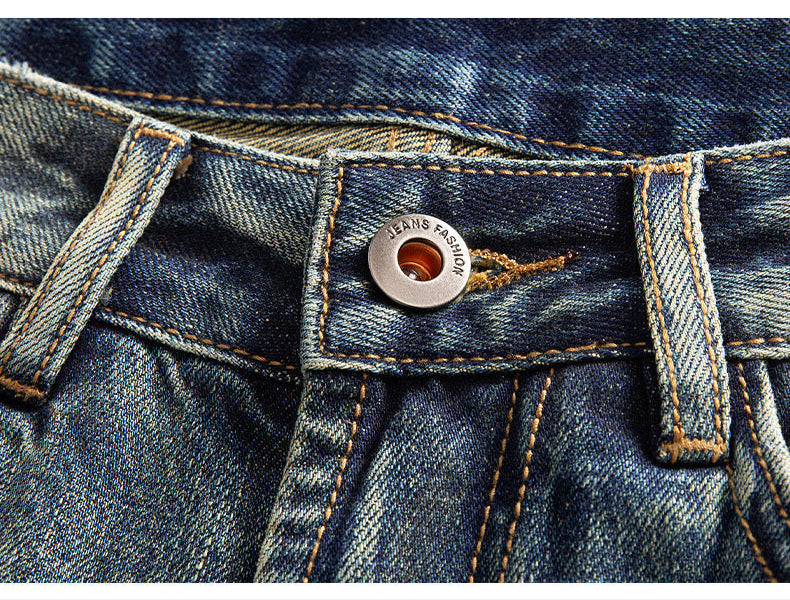 Close-up detail of jeans button with 'Jeans Fashion' branding and vintage wash denim texture