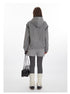 Back view of grey textured hoodie ensemble with cable knit shorts, dark grey leggings, cream leg warmers, and black sneakers. Accessorized with black leather handbag