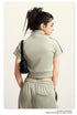 Olive green mock neck crop top with front zip and white sleeve stripes, back view