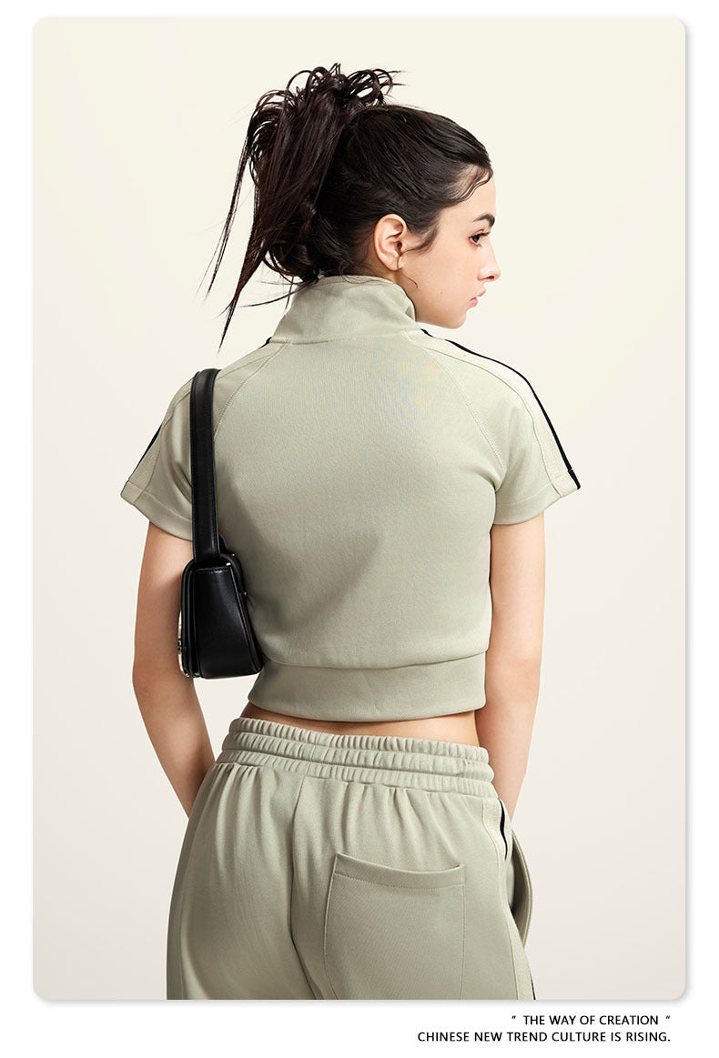 Olive green mock neck crop top with front zip and white sleeve stripes, back view
