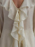 Close-up of a white blouse with ruffled details
