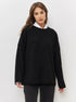 Portrait shot of woman in black knit sweater over white collar shirt against white background