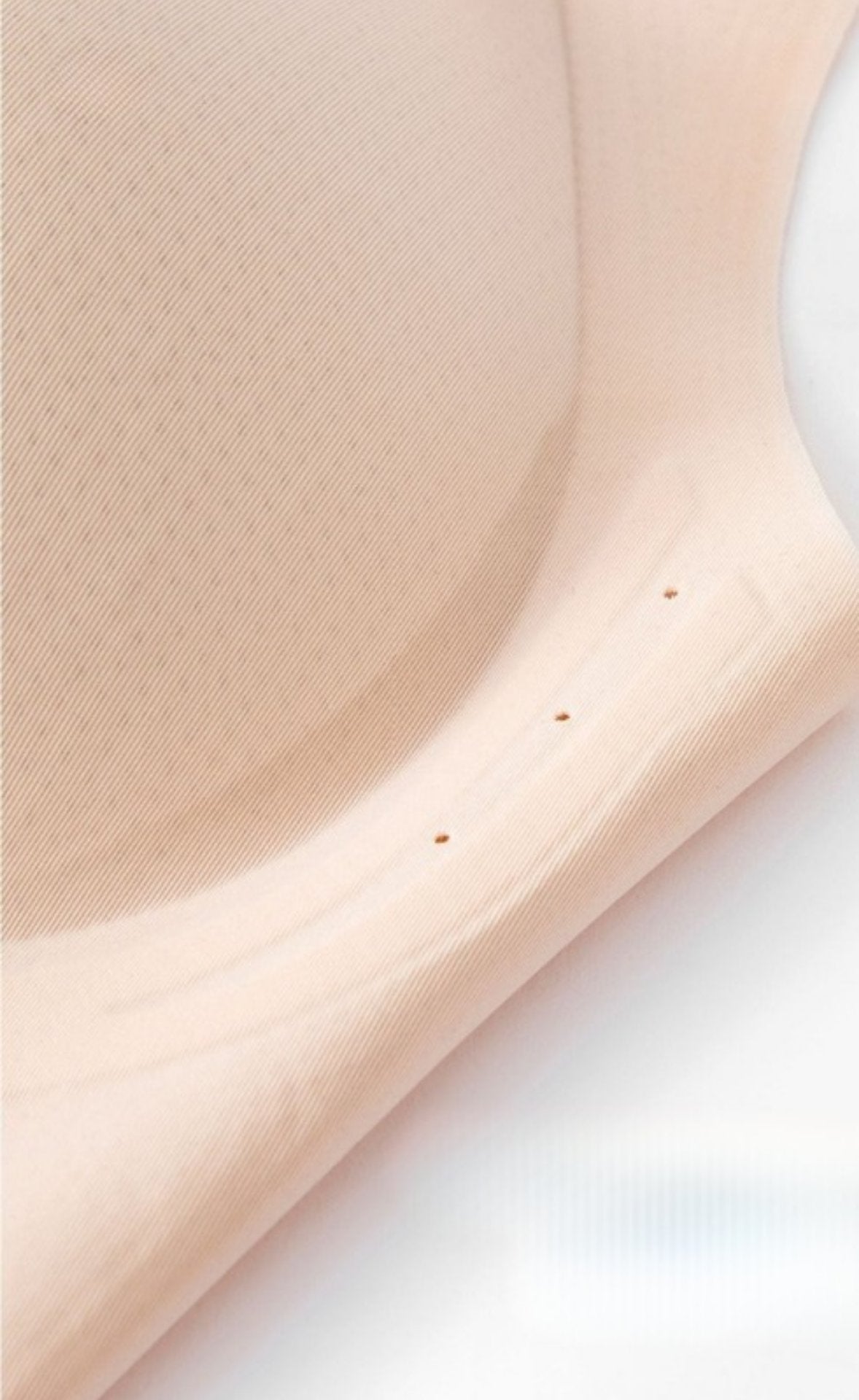 Detailed close-up of a beige seamless bra’s raised side support.