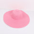 Pink wide-brimmed sun hat with a structured design, laid flat against a white background.