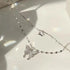 Close-up of silver double butterfly necklace with crystal details on white background