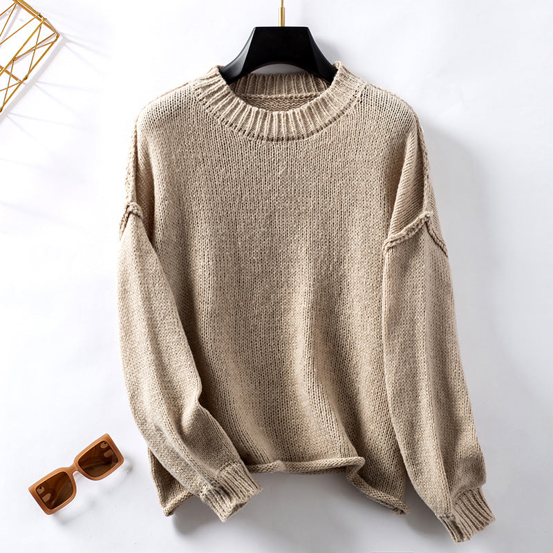 Beige chunky knit sweater with ribbed collar and seam details, styled with sunglasses
