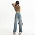 Loose-fit light blue denim jeans paired with cropped brown sweater and casual sneakers, embodying relaxed fashion