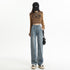 Baggy blue jeans styled with brown crop sweater, black cap, and platform sneakers for trendy streetwear look