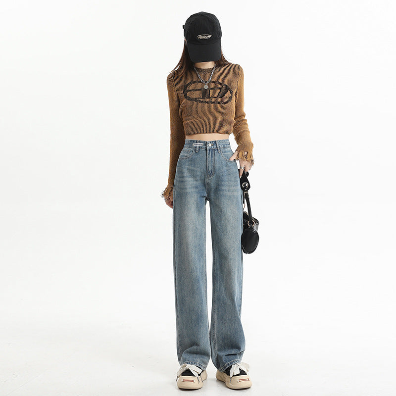 Baggy blue jeans styled with brown crop sweater, black cap, and platform sneakers for trendy streetwear look