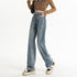 Wide-leg vintage blue jeans with distressed wash, styled with cropped brown sweater and neutral platform shoes