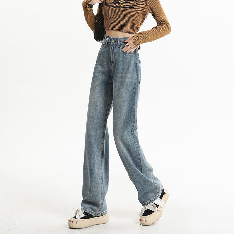 Wide-leg vintage blue jeans with distressed wash, styled with cropped brown sweater and neutral platform shoes