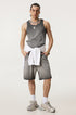 Male model wearing a gray ombre tank top and matching shorts, with a white sweater tied at the waist and silver accessories