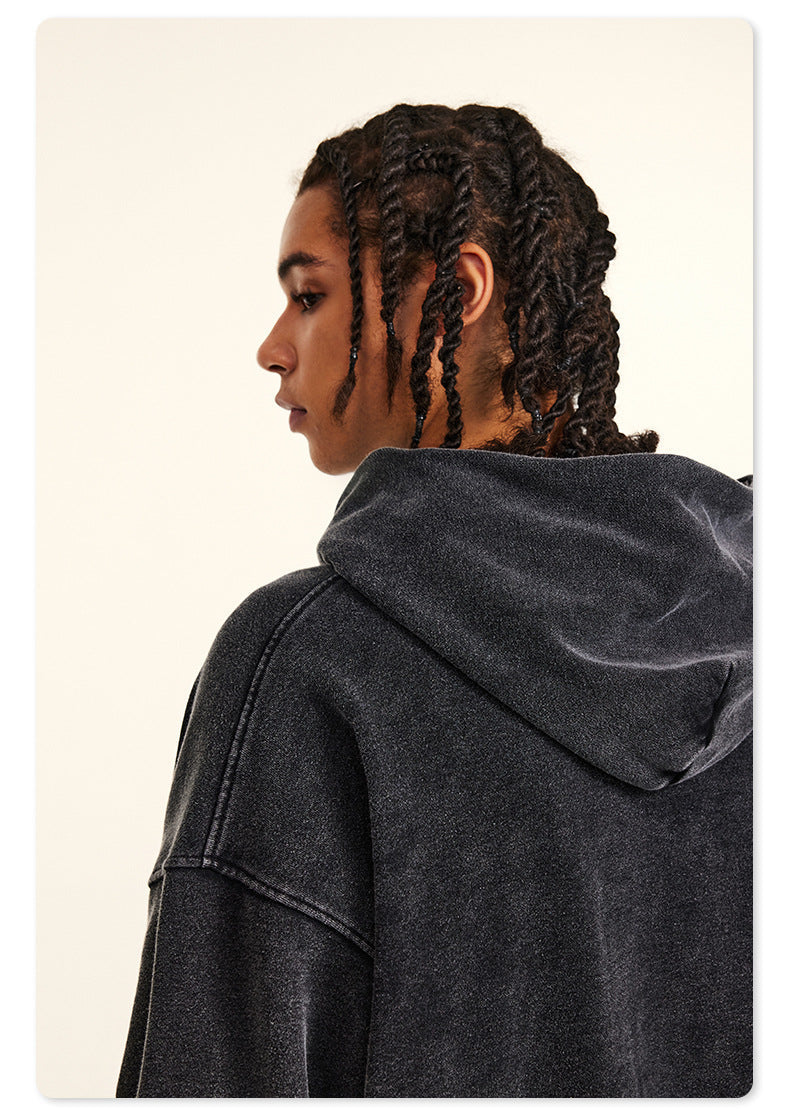 Rear view of model in black hoodie with braided hair, showing NE2C logo