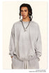 Light grey oversized sweatshirt styled with silver chain necklace and pendant, showcasing relaxed shoulder design