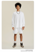 Man with afro in white sweatshirt and shorts set with chain necklace and high-top sneakers