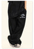 Side view of model wearing black Backstairs t-shirt and sweatpants with gold watch, distressed design against white background
