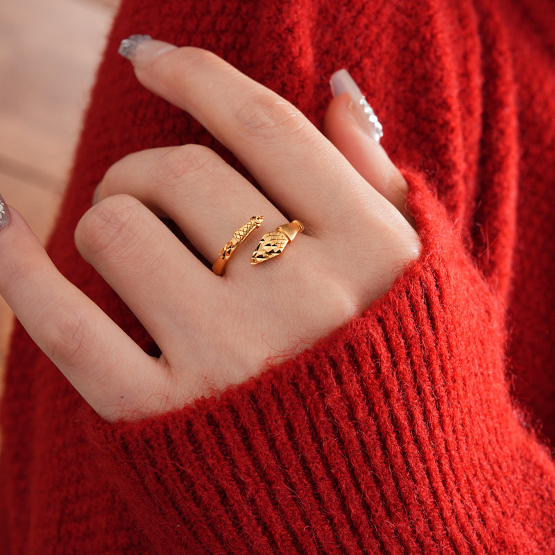 Close-up of adjustable gold snake ring on hand with red sweater