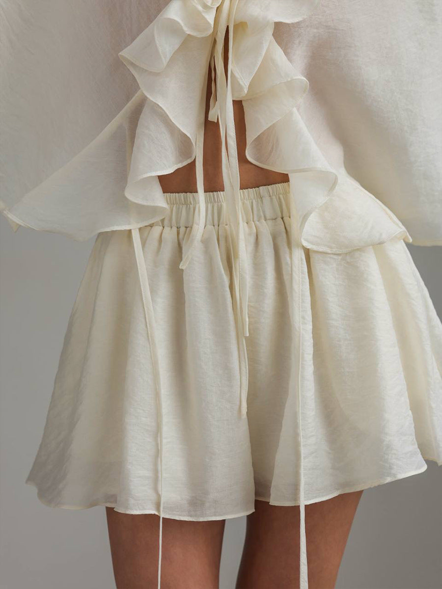 White ruffled top and shorts set on a neutral background