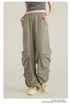 Close-up of taupe cargo pants with elasticated waistband and side pockets, paired with gray crop top and cream sneakers