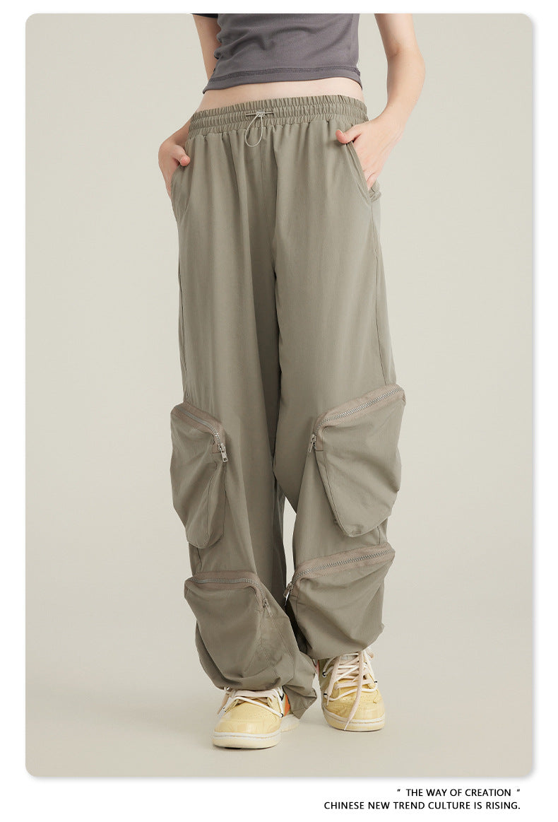 Close-up of taupe cargo pants with elasticated waistband and side pockets, paired with gray crop top and cream sneakers