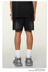 Back view of black streetwear shorts and oversized tee with metal watch accessory and chunky sneakers