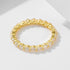 Gold eternity band with round diamonds set in prong settings around entire band, displayed on white minimalist surface