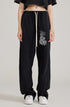Front view of model in black crop top and black sweatpants with white drawstring and graffiti-style graphic print