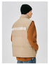 Back view of man in tan puffer vest with white NEIGTR STUDIO text across shoulders, paired with black beanie and brown sleeves