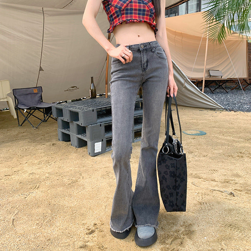 Side view of low-rise gray flare jeans paired with plaid cropped top and floral tote bag at outdoor camping area