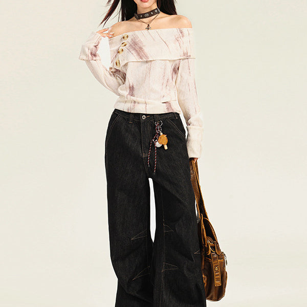 A woman is posing in a cream off-shoulder button top with black wide-leg jeans, leather choker, and brown messenger bag on light background