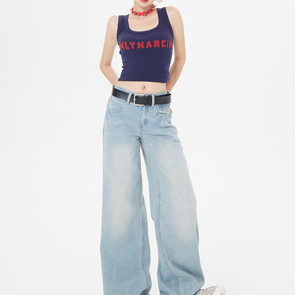 Model wearing navy MLYNARCIN crop tank, light wash wide-leg jeans, white sneakers, and sunglasses against white backdrop