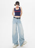 Model wearing navy MLYNARCIN crop tank, light wash wide-leg jeans, white sneakers, and sunglasses against white backdrop