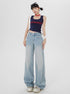 Full-length shot of model in MLYNARCIN navy tank top and extra-wide light wash denim jeans on white background