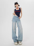 Standing model in navy crop tank, wide-leg light wash jeans, accessorized with sunglasses and white shoulder bag